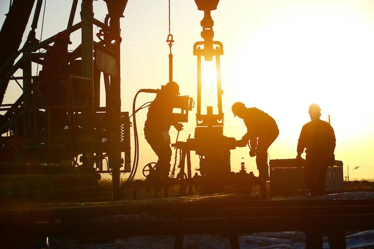 Oil workers drilling for oil.