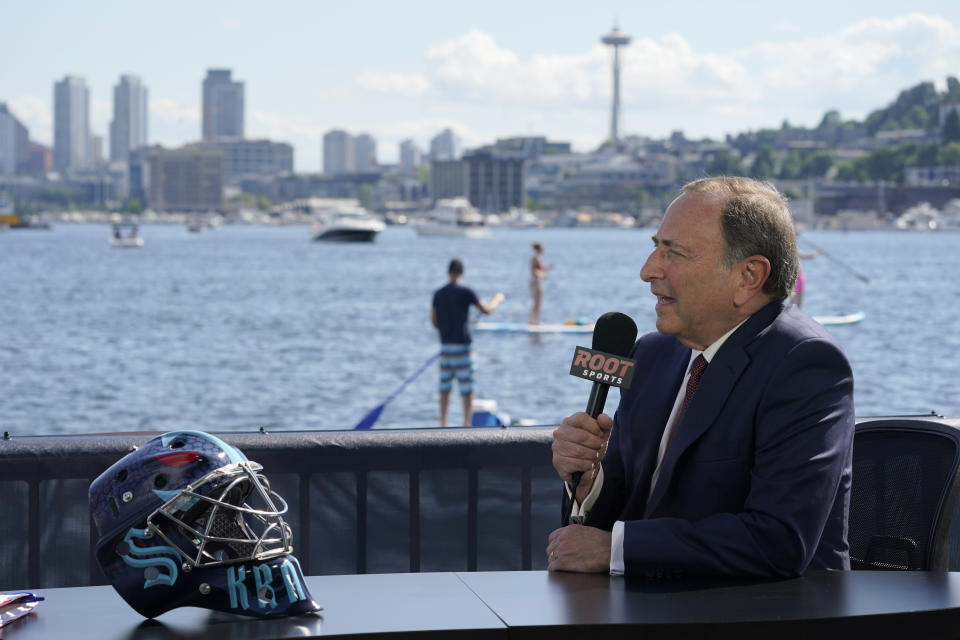 NHL Commissioner Gary Bettman takes part in an interview next to a Seattle Kraken NHL hockey goalie helmet Wednesday, July 21, 2021, during the Kraken's expansion draft event in Seattle. (AP Photo/Ted S. Warren)