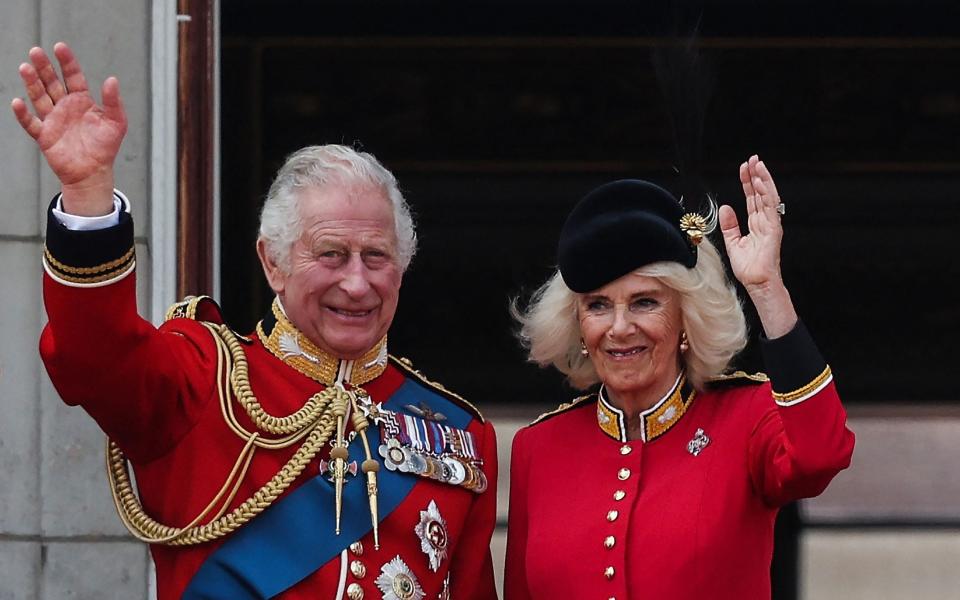 Britain's King Charles III and Britain's Queen Camilla wave from the balcony of Buckingham Palace after attending the King's Birthday Parade - ADRIAN DENNIS/AFP