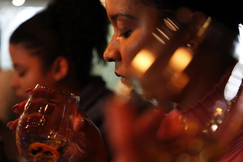 A gin tasting session is held at the Botlierskop Private Game Reserve, near Mossel Bay, South Africa, Monday, Oct. 23, 2019. After about five sizeable bags of dung are collected for a batch of 3,000 to 4,000 bottles of the gin, the droppings are dried and crumbled, then washed to remove dirt and sand. Eventually only the remains of the fruits, flowers, leaves and bark eaten by the elephants are left behind. (AP Photo/Denis Farrell)