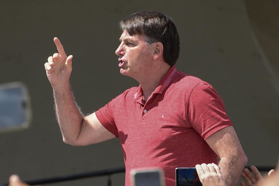 Brazilian President Jair Bolsonaro speaks after joining his supporters who were taking part in a motorcade to protest against quarantine and social distancing measures to combat the new coronavirus outbreak in Brasilia on April 19. (Photo: EVARISTO SA via Getty Images)