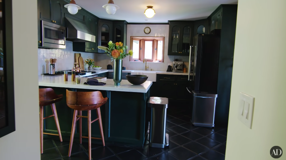 A kitchen with dark-toned cupboards and dark floor tiles