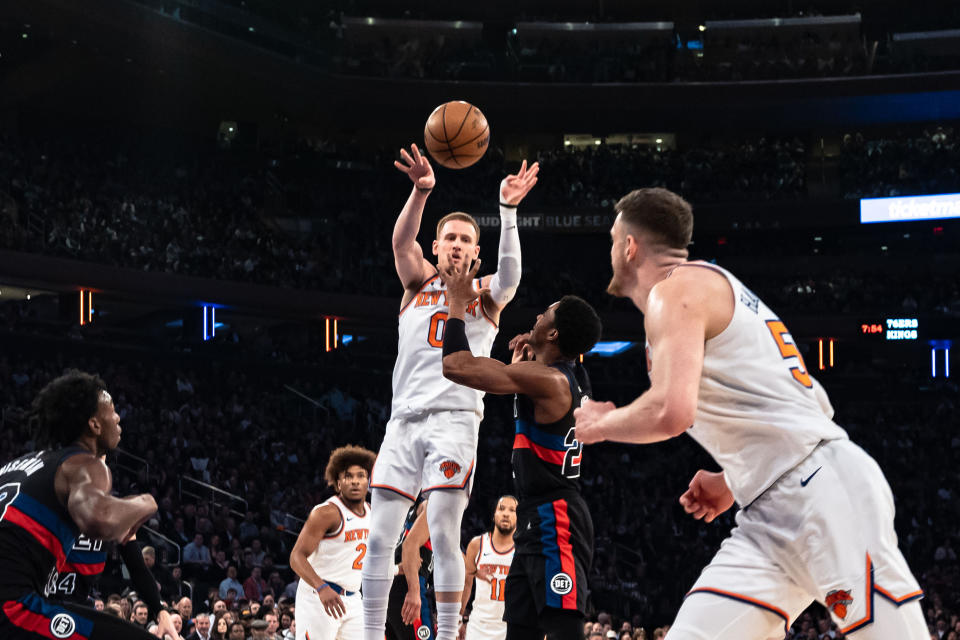 New York Knicks' Donte DiVincenzo, left, passes to teammate Isaiah Hartenstein, front, during the first half of an NBA basketball game in New York, Monday, March 25, 2024. (AP Photo/Peter K. Afriyie)