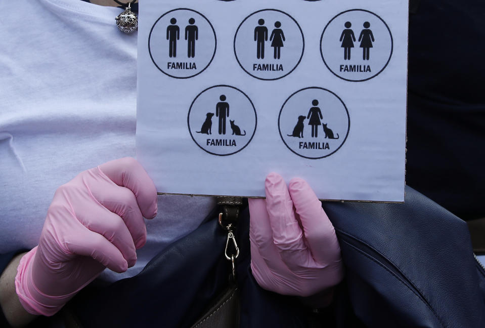 A woman holds a sign representing different kind of families during a march to protest the World Congress of Families, in Verona, Italy, Saturday, March 30, 2019. A congress in Italy under the auspices of a U.S. organization that defines family as strictly centering around a mother and father has made Verona — the city of Romeo and Juliet — the backdrop for a culture clash over family values, with a coalition of civic groups mobilizing against what they see as a counter-reform movement to limit LGBT and women's rights. (AP Photo/Antonio Calanni)