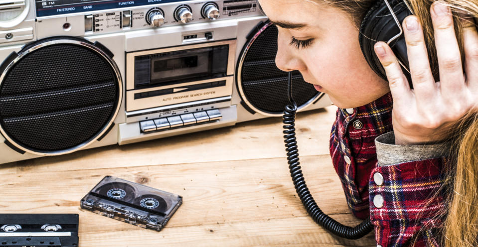 A young person listening to a boombox