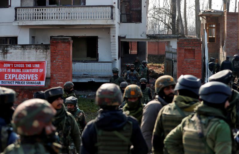 Indian army soldiers stand outside a house after a gun battle with suspected militants in Hokarsar