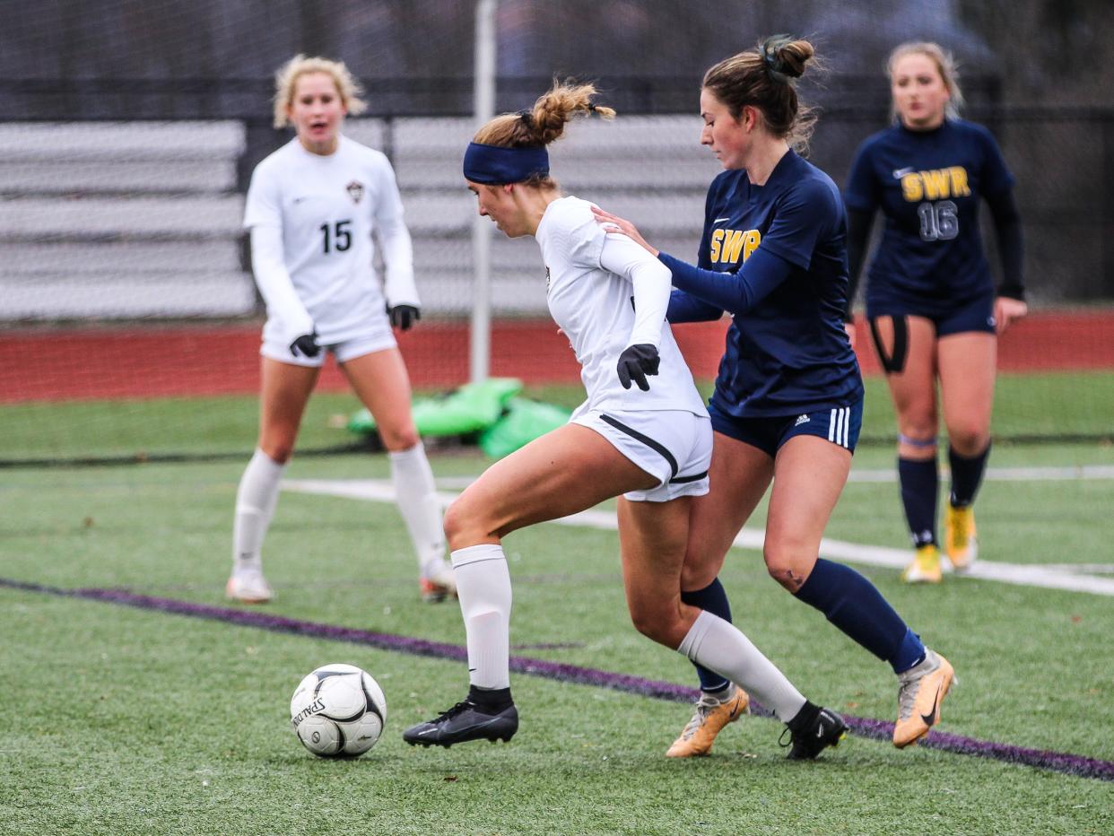 Rye's Lyla Keenan tries to shield the ball from a SWR defender during the NYSPHSAA Class A girls soccer state championship match at Cortland High School on Sunday, Nov. 12, 2023.