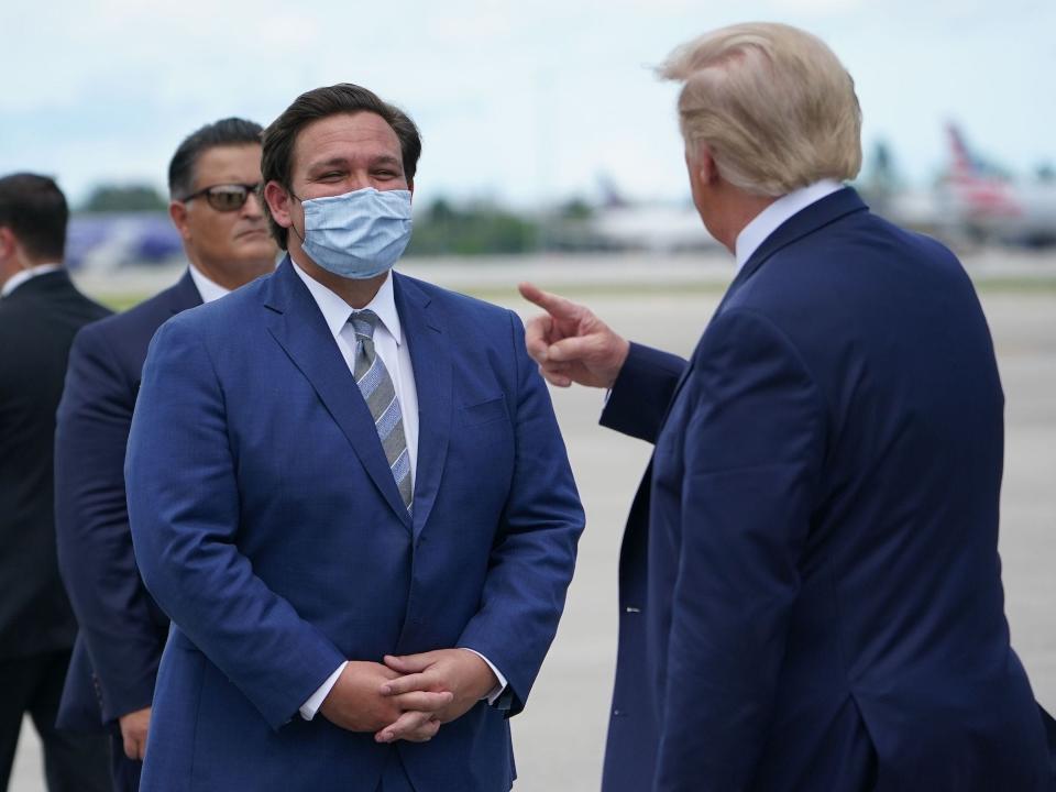 President Donald Trump speaks with Governor of Florida Ron DeSantis after stepping off Air Force One upon arrival at Palm Beach International Airport, in West Palm Beach, Florida on September 8, 2020.