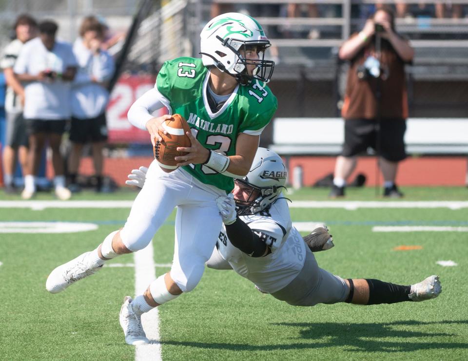 Mainland's John Franchini runs the ball as Egg Harbor Township's Eric Russ closes in to make the stop during the second annual Battle at the Beach football showcase played at Ocean City High School on Friday, August 26, 2022. 