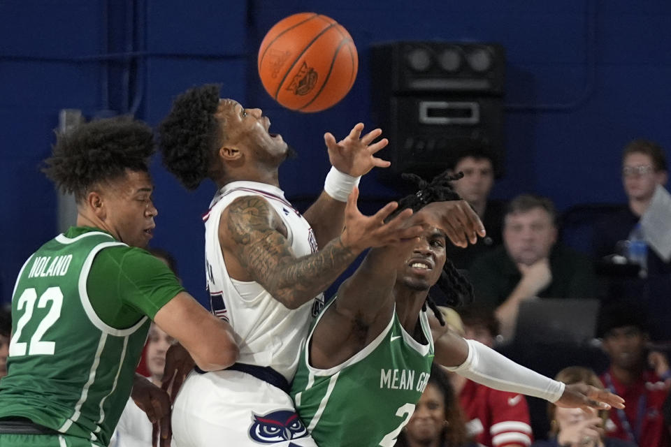 Florida Atlantic guard Alijah Martin, center, loses control of the ball as he is guarded by North Texas guards CJ Noland (22) and Jason Edwards (2) during the second half of an NCAA college basketball game, Sunday, Jan. 28, 2024, in Boca Raton, Fla. (AP Photo/Wilfredo Lee)