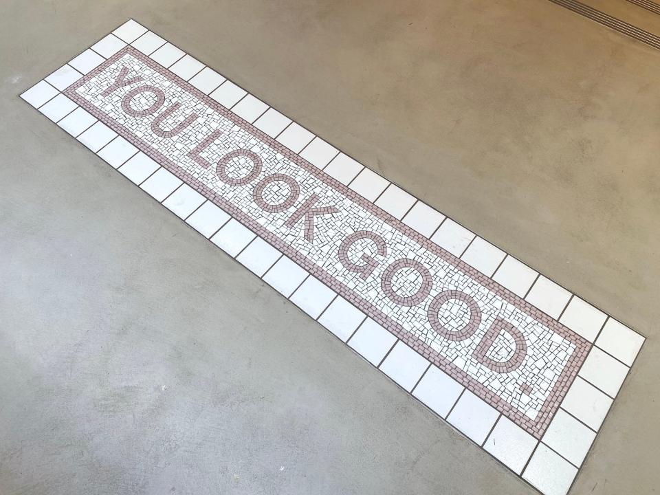 A "you look good" tile display in Glossier's NYC flagship store.