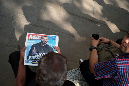 A man reads a newspaper with the picture of presidential candidate Nayib Bukele, who proclaimed himself the winner of the presidential election, in San Salvador, El Salvador, February 4, 2019. REUTERS/Jose Cabezas
