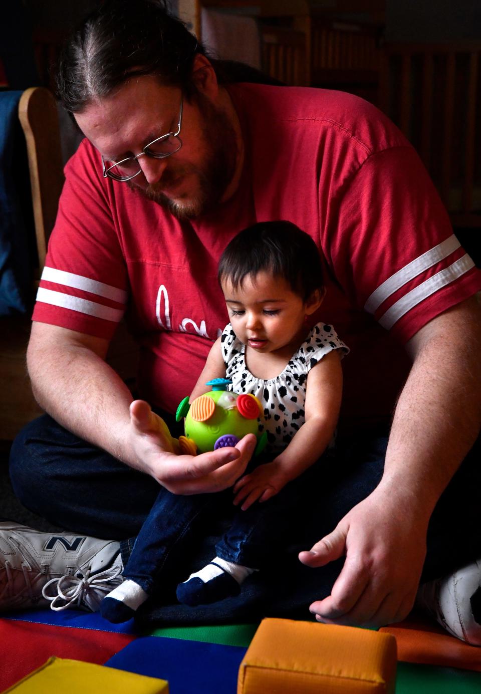 Sam Morgan tends to one of his students in the 6-12-month-old room at Vine Street location.