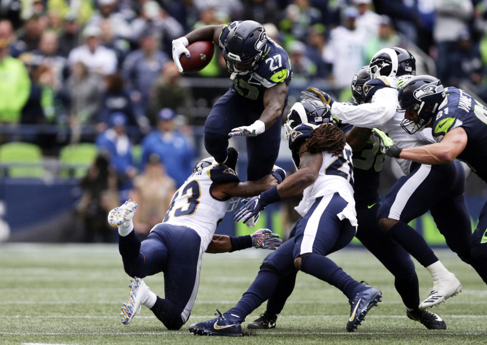 Seattle Seahawks running back Mike Davis (27) leaps over Los Angeles Rams strong safety John Johnson, lower left, during the second half of an NFL football game, Sunday, Oct. 7, 2018, in Seattle. (AP Photo/Scott Eklund)