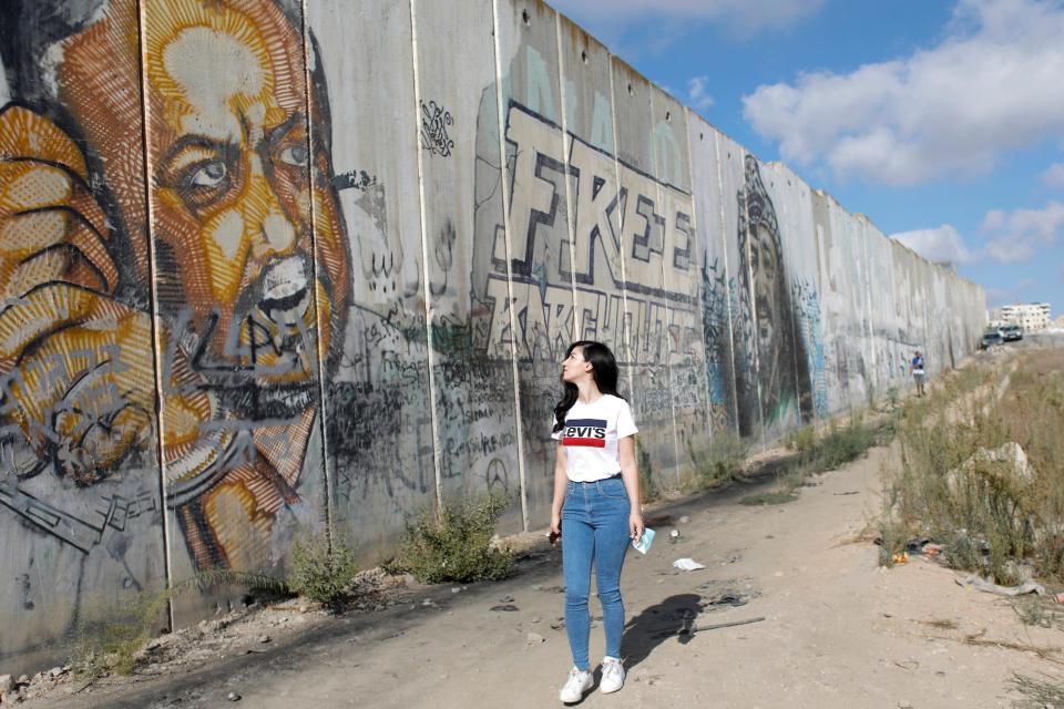 Palestinian woman looks at a mural depicting Jailed Fatah leader Marwan Barghouti.