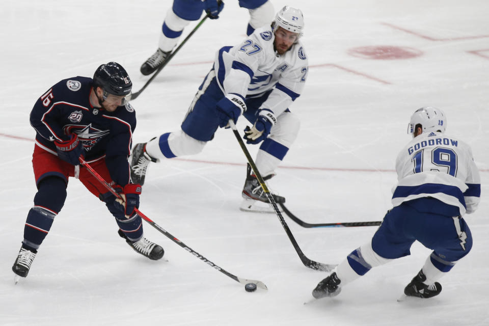 Columbus Blue Jackets' Max Domi, left, carries the puck as Tampa Bay Lightning's Ryan McDonagh, center, and Barclay Goodrow during the second period of an NHL hockey game Thursday, Jan. 21, 2021, in Columbus, Ohio. (AP Photo/Jay LaPrete)