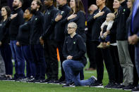 NEW ORLEANS, LOUISIANA - JANUARY 13: A teacher from the Extra Yard for Teachers charity kneels during the National Anthem prior to the Clemson v LSU game in the College Football Playoff National Championship game at Mercedes Benz Superdome on January 13, 2020 in New Orleans, Louisiana. (Photo by Kevin C. Cox/Getty Images)