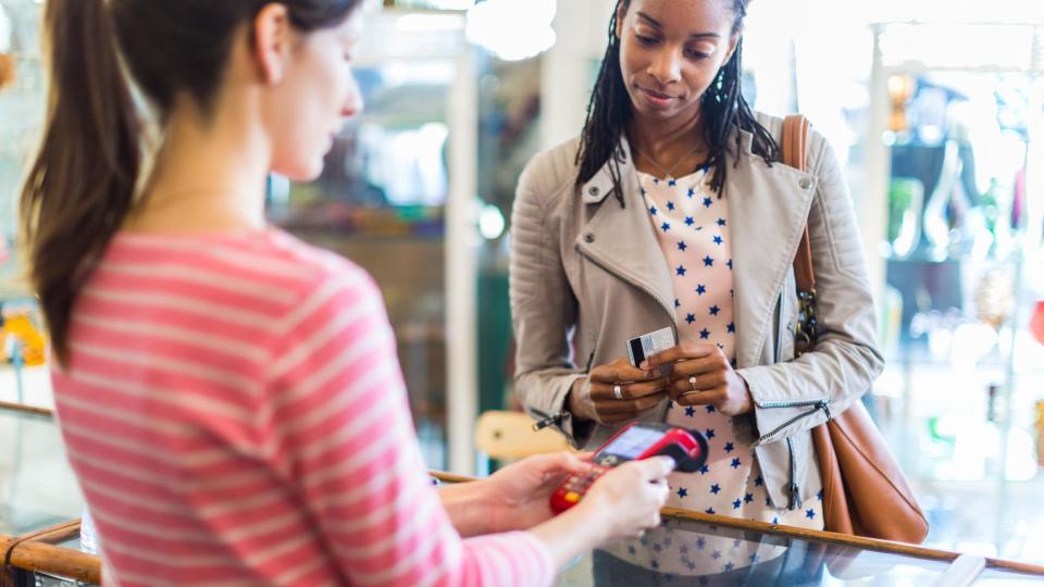 A woman about to buy something using in shope with a debit or credit card