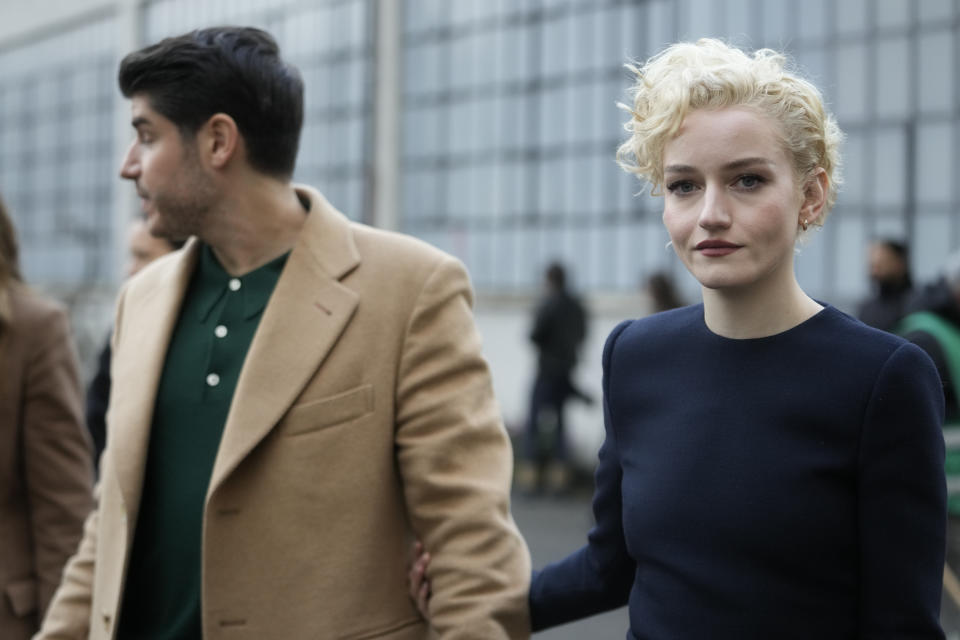 Actress Julia Garner, right, and her husband Mark Foster leave at the end of the unveiling of the Gucci women's Fall-Winter 2024-25 collection presented in Milan, Italy, Friday, Feb. 23, 2024. (AP Photo/Luca Bruno)