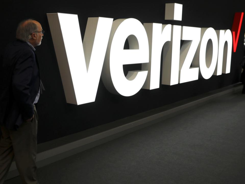 FILE PHOTO: A man stands next to the logo of Verizon at the Mobile World Congress in Barcelona, Spain, February 26, 2019. REUTERS/Sergio Perez