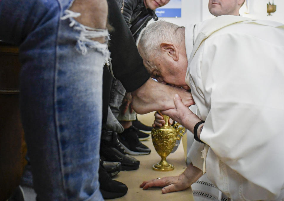 In this picture made available by Vatican Media Pope Francis kisses the feet of the inmates of Rome's penitentiary of Casal del Marmo, Thursday, April 6, 2023. In a Holy Thursday ritual symbolizing humility, Pope Francis washed and wiped dry the bare feet of a dozen residents of a Rome juvenile prison, assuring them of their dignity and telling them "any of us" can fall into sin. (Vatican Media handout via AP)