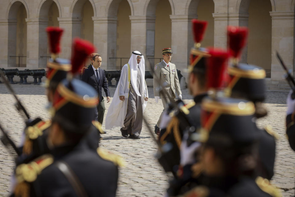 France's Defense Minister Sebastien Lecornu, left, welcome United Arab Emirates' President Sheikh Mohammed Bin Zayed, center, during a welcome ceremony at the Invalides monument in Paris, Monday, July 18, 2022. United Arab Emirates' President Sheikh Mohammed Bin Zayed is for a two-days visit in France. (AP Photo/Thomas Padilla, Pool)