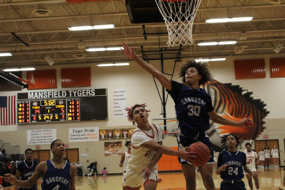 Mansfield Senior's Nathaniel Haney makes a no-look pass as Sandusky's Chayce Carr contests.