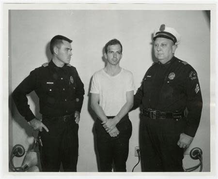 Lee Harvey Oswald, accused of assassinating former U.S. President John F. Kennedy, is pictured with Dallas police Sgt. Warren (R) and a fellow officer in Dallas, in this handout image taken on November 22, 1963. REUTERS/Dallas Police Department