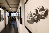 <p>A group of visitors walk through a corridor next to the artwork ‘Golf Sale’ by British Banksy during the exhibition ‘The Art of Banksy’ in Berlin, Germany on June 20, 2017. (Felipe Trueba/EPA/REX/Shutterstock) </p>