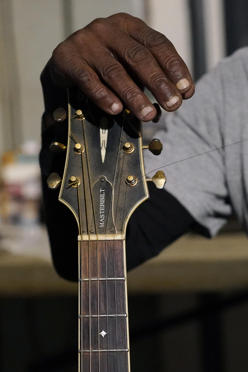 Resting his hand against the head of his acoustic guitar, blues performer Jimmy "Duck" Holmes' fingertips show the wear after years of performing without a pic at the Blue Front Cafe in Bentonia, Miss., Jan. 21, 2021. Holmes' ninth album, "Cypress Grove," has earned a Grammy nomination for the Best Traditional Blues Album. (AP Photo/Rogelio V. Solis)
