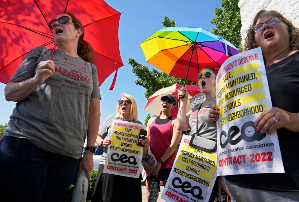 June 21, 2022; Columbus, Ohio, United States;  Members of the Columbus Education Association hold up umbrellas against the sun as they rallied outside Tuesday evening's Columbus City Schools board meeting in temperatures that exceeded 90 degrees. Mandatory Credit: Barbara J. Perenic/Columbus Dispatch