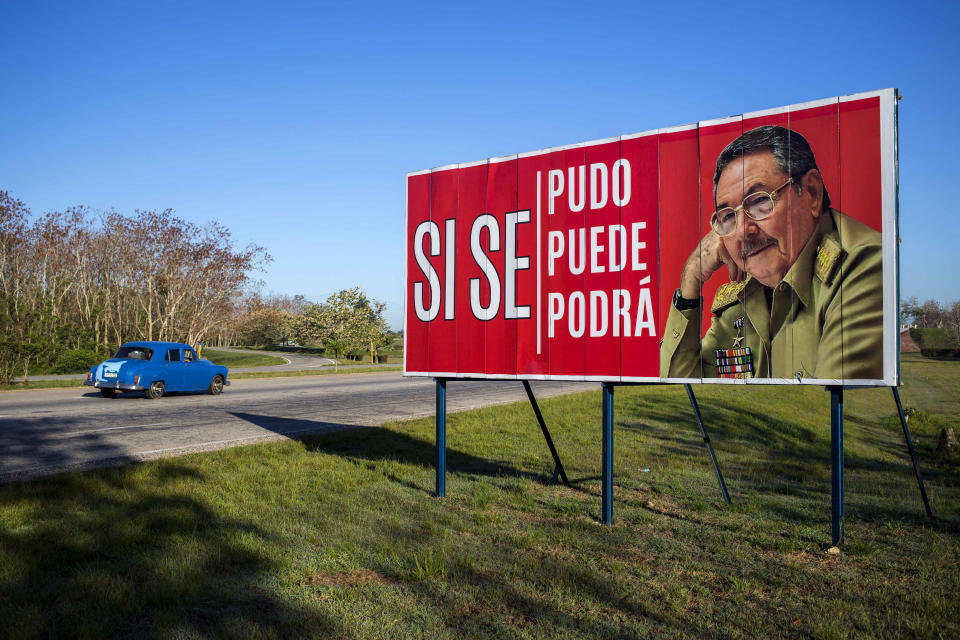 FILE - In this April 18, 2018 file photo, a car drives by a billboard that reads in Spanish "Yes we could, yes we can, yes we will" alongside a picture of Cuban President Raul Castro on the outskirts of Havana, Cuba. On Friday, April 16, 2021, Castro formally announced he'd step down as head of the Communist Party, leaving Cuba without a Castro in an official position of command for the first time in more than six decades. (AP Photo/Desmond Boylan, File)