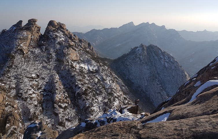 A rocky mountain vista with streaks of snow.