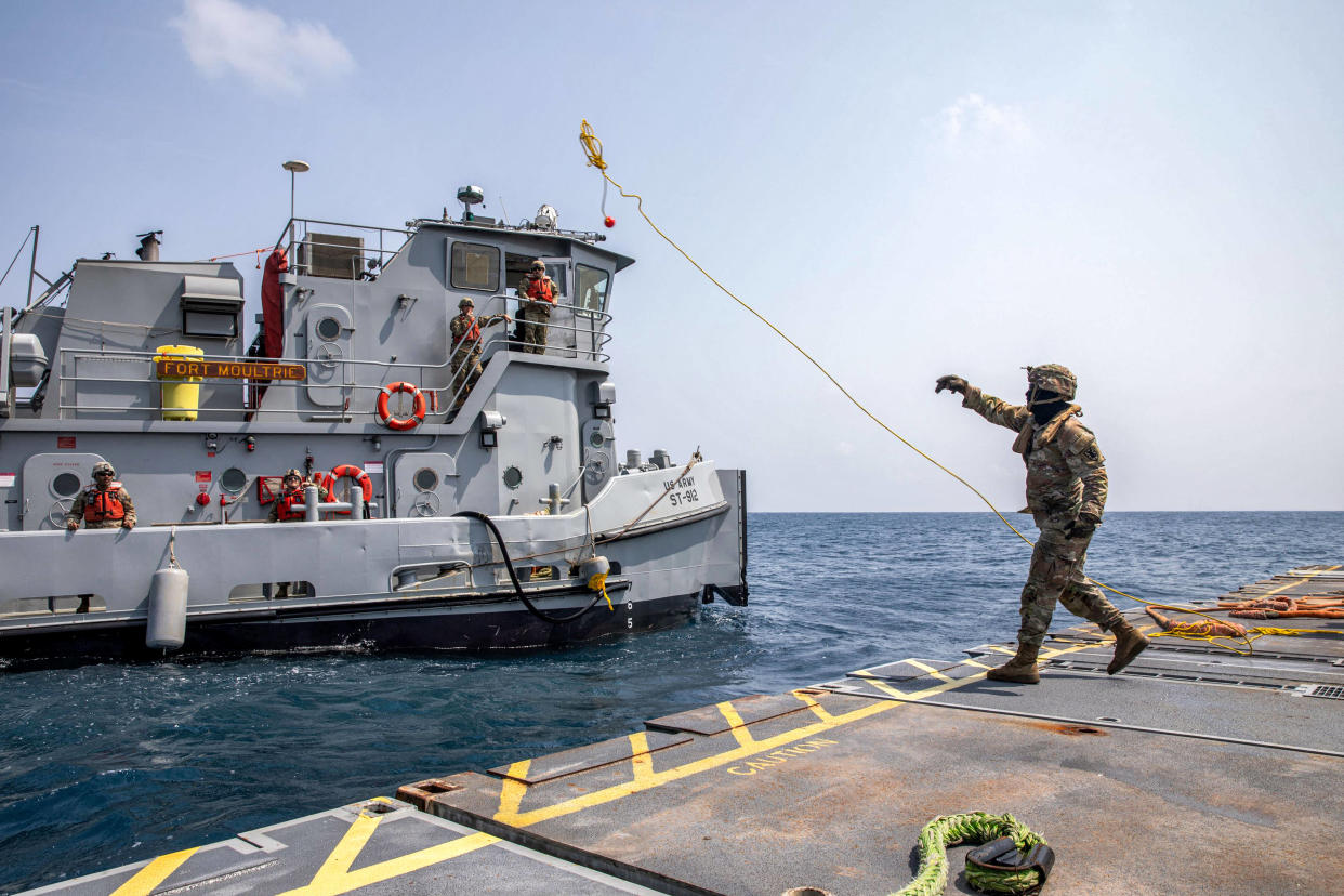 Photo d’illustration prise le 1er mai 2024 montre un soldat de l’armée américaine lançant une ligne au remorqueur depuis le quai flottant qui aidera à livrer de l’aide humanitaire à la bande de Gaza.