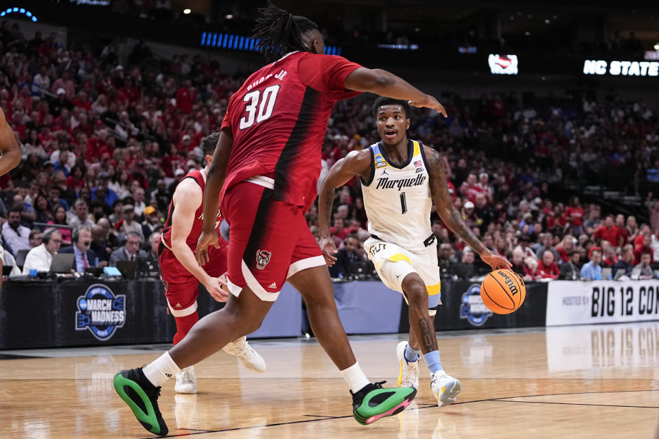 Marquette's Kam Jones (1) drives against North Carolina State's DJ Burns Jr. (30) during the second half of a Sweet 16 college basketball game in the NCAA Tournament in Dallas, Friday, March 29, 2024. (AP Photo/Tony Gutierrez)