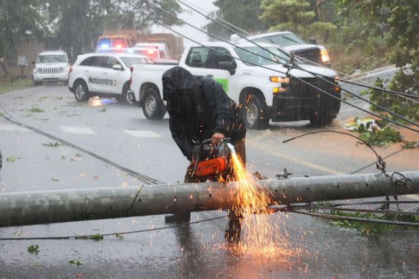 PHOTO: A worker cuts an electricity pole that was downed by Hurricane Fiona as it blocks a road in Cayey, Puerto Rico, on Sept. 18, 2022. (Stephanie Rojas/AP)