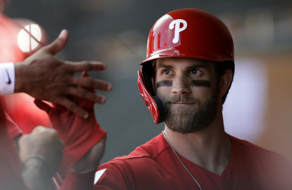 Bryce Harper, de los Filis de Filadelfia, da palmadas a sus compañeros durante un encuentro de pretemporada ante los Azulejos de Toronto, el sábado 9 de marzo de 2019 (AP Foto/Chris O'Meara)