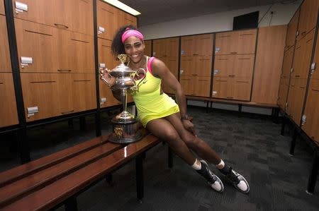 Serena Williams of the U.S. poses with the women's singles trophy in the players' locker room after she defeated Maria Sharapova of Russia at the Australian Open tennis tournament in Melbourne January 31, 2015. REUTERS/Fiona Hamilton/Tennis Australia/Handout via Reuters