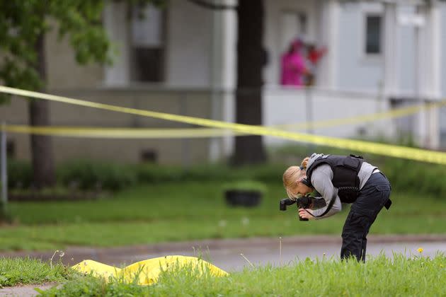 A crime scene investigator photographs a body at Olson Memorial High, in Minneapolis, where a person was shot in killed in 2016.