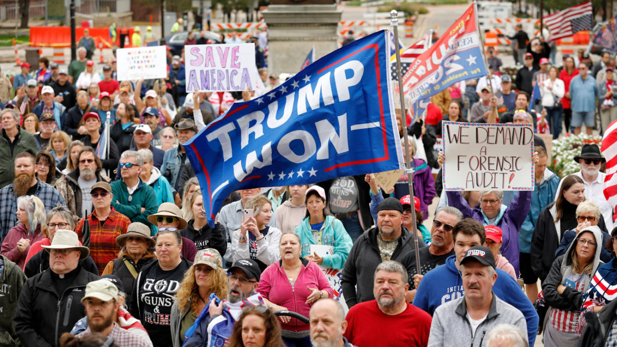 People demonstrate outside the Michigan Capitol. They hold signs reading: Trump won and We demand a forensic audit.