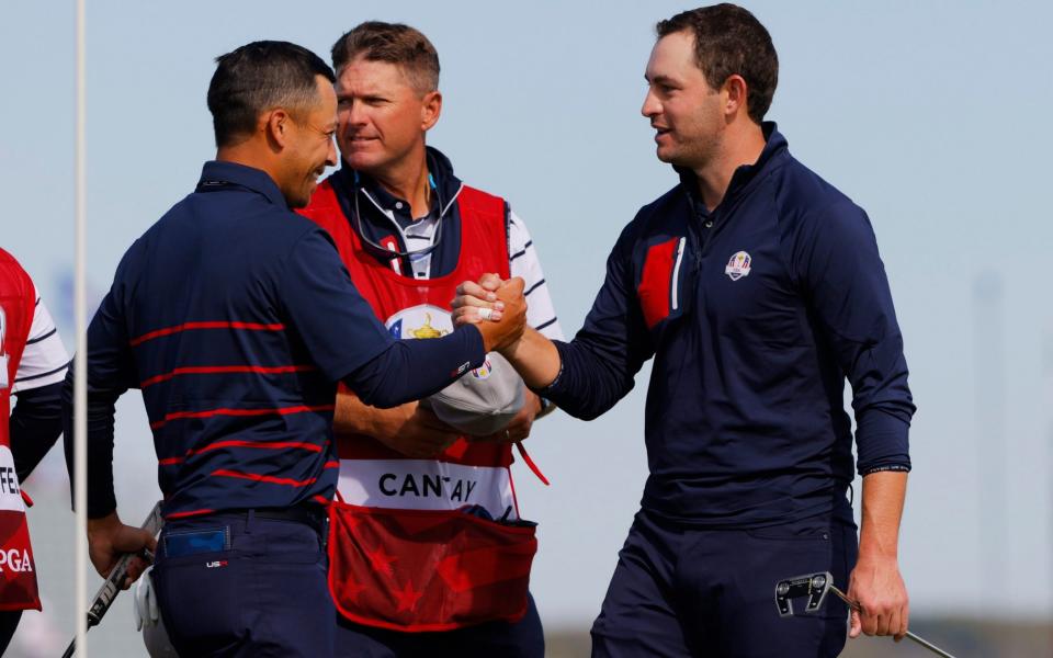 Team USA's Xander Schauffele celebrates with Team USA's Patrick Cantlay on the 15th green - Reuters