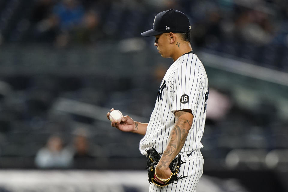 New York Yankees relief pitcher Jonathan Loaisiga looks at the ball after allowing four runs to the Kansas City Royals during the eighth inning of a baseball game, Tuesday, June 22, 2021, at Yankee Stadium in New York. (AP Photo/Kathy Willens)