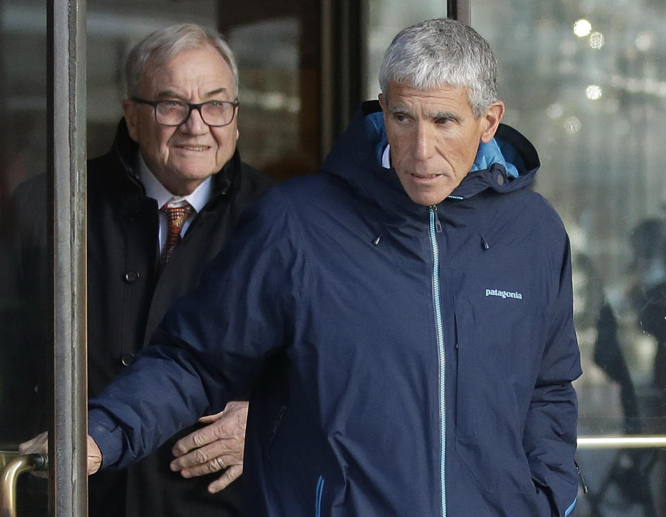 William "Rick" Singer, front, founder of the Edge College & Career Network, exits federal court in Boston on Tuesday, March 12, 2019, after he pleaded guilty to charges in a nationwide college admissions bribery scandal. (AP Photo/Steven Senne)