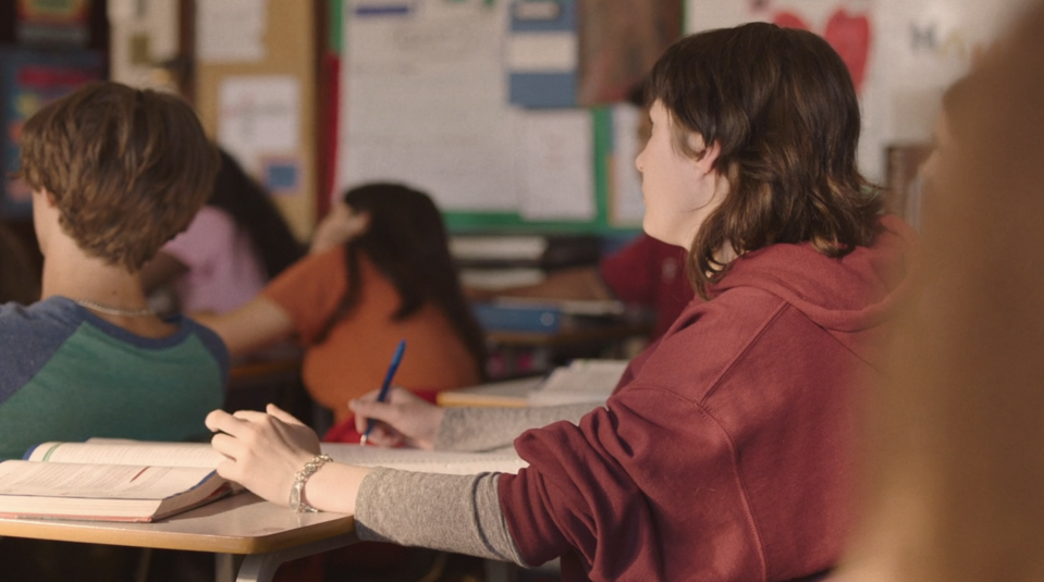 Student sitting in class in front of a desk