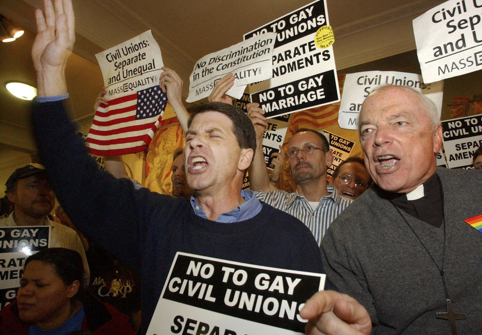 The Rev. Joshua Cotter, of the Unification Church in Bridgeport, Conn., center, and George Welles, of the Church of Our Savior, in Milton, Mass., right, protest against same-sex marriage and civil unions, Monday, March 29, 2004, at the Statehouse in Boston. The Massachusetts Legislature gave final approval in 2004 to a constitutional amendment that would ban gay marriage but legalize civil unions; the state Supreme Court subsequently ordered the legalization of same-sex marriage across the state. (AP Photo/Lisa Poole)