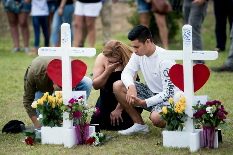 People visit a cross for Christopher Stone at a memorial for the victims of the Santa Fe High School shooting