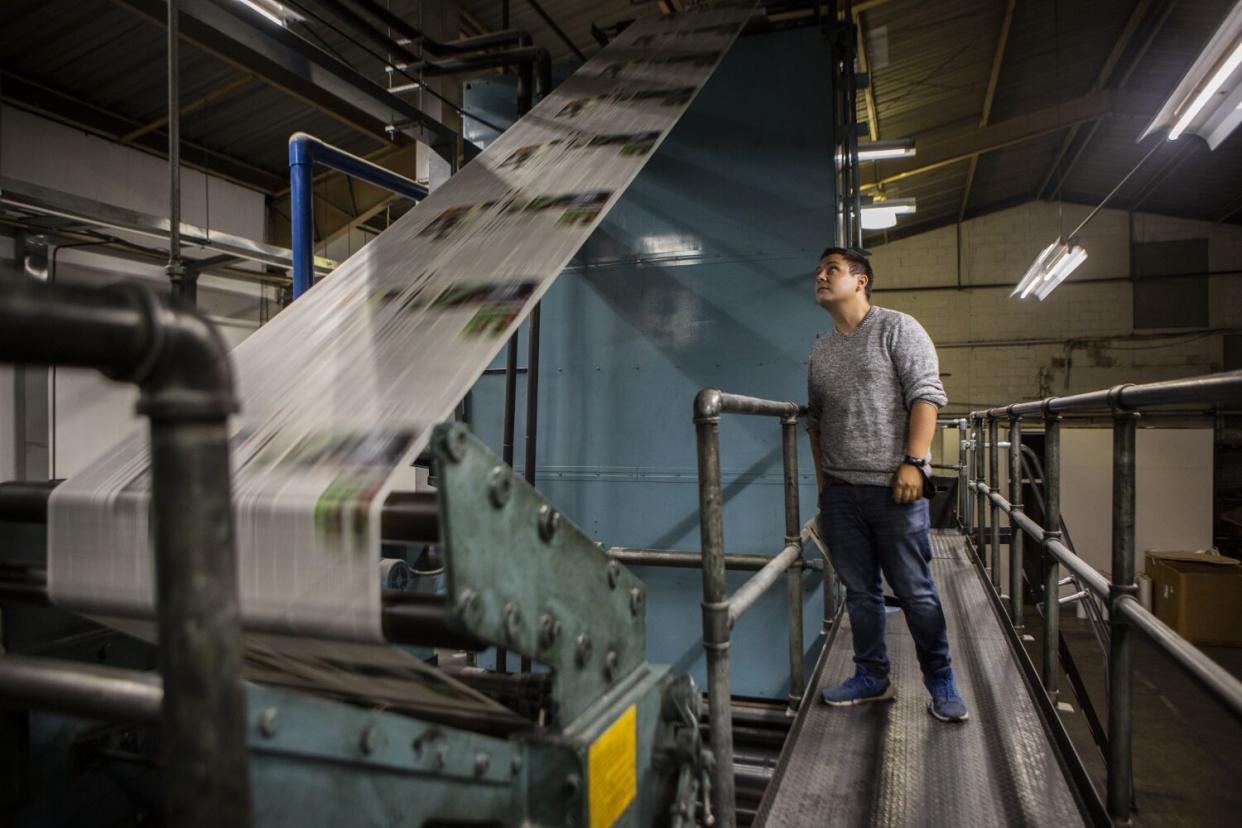 Ramon Zamora, Jose Ruben Zamora's son, checks on the freshly printed newspapers