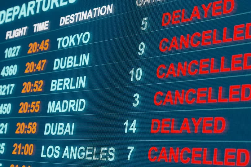 close-up of an airport board showing delays and cancellations