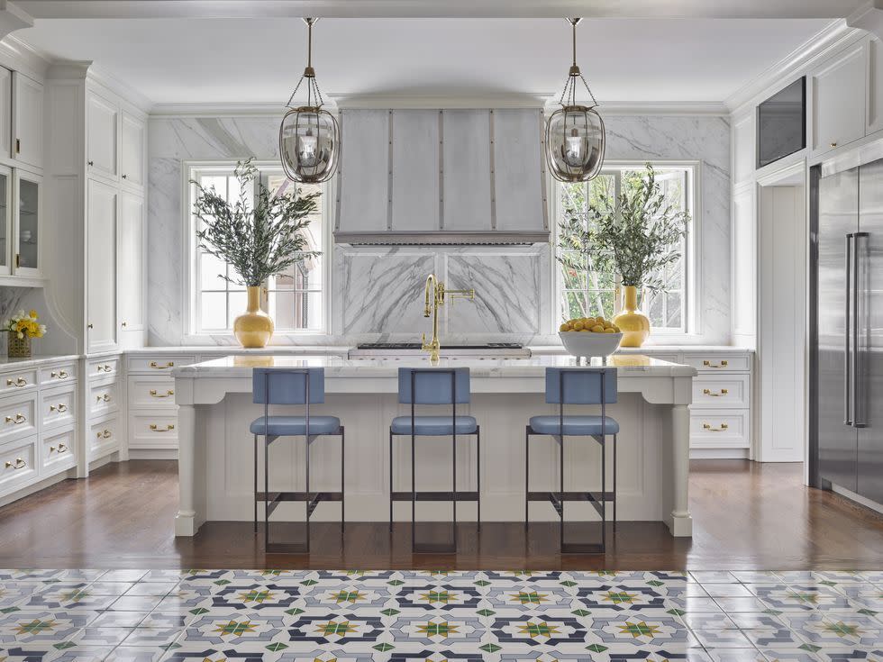a kitchen with a marble countertop and blue stools