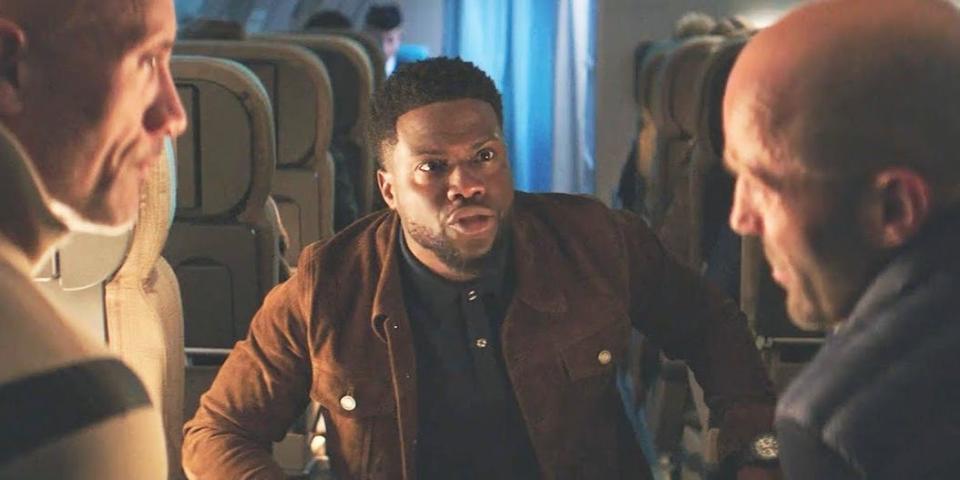 Kevin Hart talking to Dwayne Johnson and Jason Statham on a plane